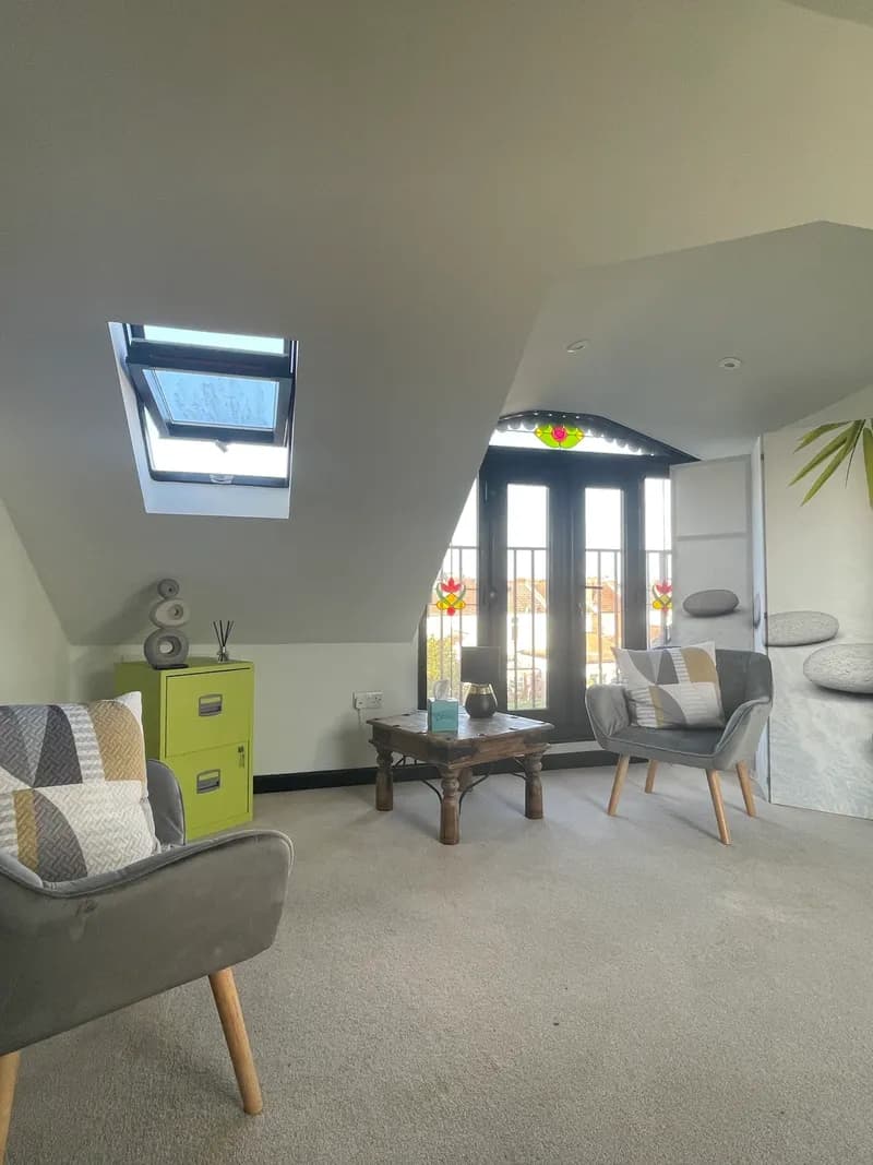 The therapy room with natural light, stained glass windows and comfortable seating